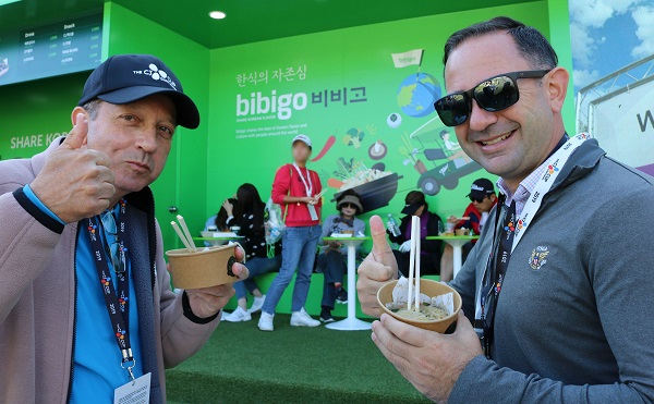 지난 20일 더CJ컵을 방문한 외국인 갤러리들이 비비고 부스에서 잡채를 맛보고 호평하고 있다..jpg