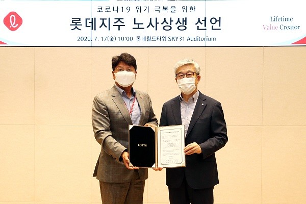 롯데지주 사용자 대표 송용덕 부회장과 근로자 대표 김봉세 수석(왼쪽)이 노사협력 선언문에 서명한 뒤 기념사진을 촬영하고 있다.