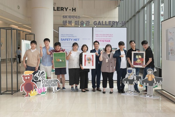 기념식에 참석한 SK하이닉스 관계자와 ‘오티스타’ 소속 자폐인 디자이너들이 사진을 찍고 있다. 왼쪽 다섯 번째부터 오티스타 이소현 대표, SK하이닉스 이일우 EE담당