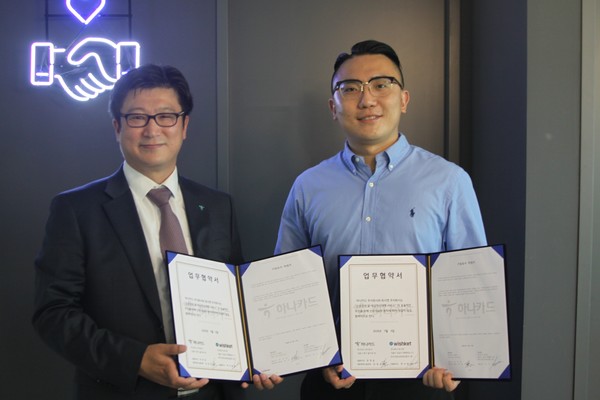 ▲26일 위시켓 본사에서 진행된 ‘금융 비즈니스 모델 구축을 위한 업무 제휴 체결식’에서 한경호 하나카드 글로벌&신성장사업본부장(왼쪽)과 박우범 위시켓 대표(오른쪽)이 기념촬영을 하고 있다.