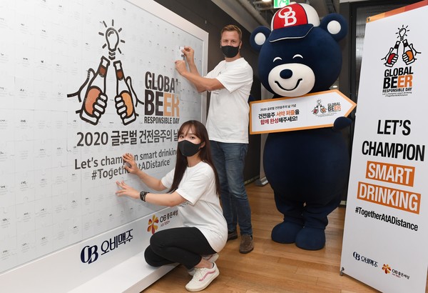 ▲배하준 오비맥주 대표(오른쪽)가 건전음주 서약 퍼즐 마지막 조각에 이름을 적어 퍼즐을 완성하고 있다.