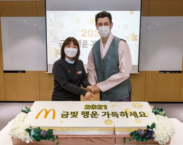 ▲한국맥도날드 앤토니 마티네즈 대표(오른쪽)와 서울시청점 김아영 점장이 4일 한국맥도날드 본사에서 열린 신년맞이 첫 비대면 사내 타운홀 행사에서 떡 케이크 커팅식을 하고 있다.