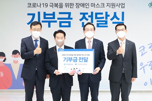 ▲ 우리금융그룹은 4일 ‘코로나19 극복을 위한 장애인 마스크 지원사업’ 기부금 전달식을 열었다. 손태승(왼쪽 세번째) 우리금융그룹 회장과 김동범(왼쪽 첫번째)한국장애인단체총연맹 사무총장, 최공열(왼쪽 두번째) 한국장애인단체총연맹 상임대표, 최동수(왼쪽 네번째) 우리금융그룹 부사장이 기념촬영을 하고 있다.