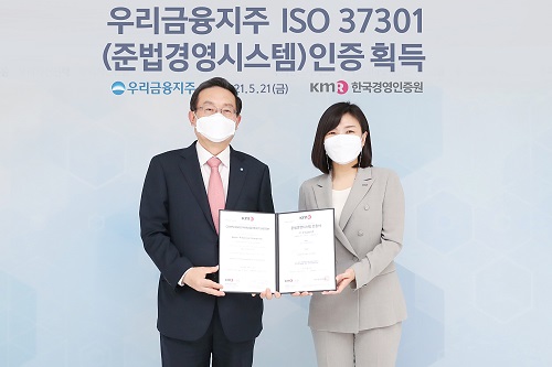 ▲ 우리금융지주가 국내 금융권 최초로 준법경영시스템 국제표준(ISO 37301) 공식 인증을 획득했다. 지난 21일 서울 중구 우리금융그룹 본사에서 손태승 우리금융그룹 회장(왼쪽)과 한국경영인증원 황은주 원장이 기념촬영을 하고 있다.