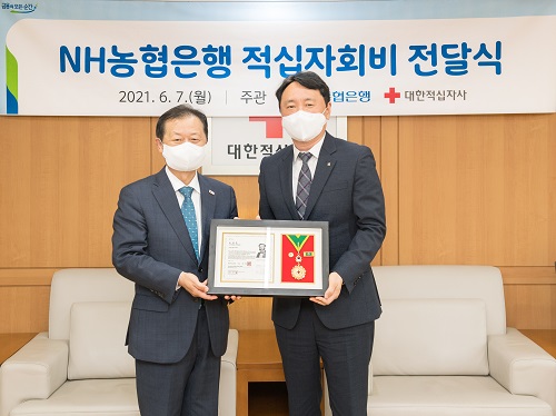 ▲ 지난 7일 대한적십자 본사에서 권준학 농협은행장(사진 오른쪽)이  대한적십자사 신희영 회장(사진 왼쪽)으로부터 적십자 회원 유공장 중 최고 영예인 ‘최고명예대장’을 수여받고 기념촬영을 하고 있다.