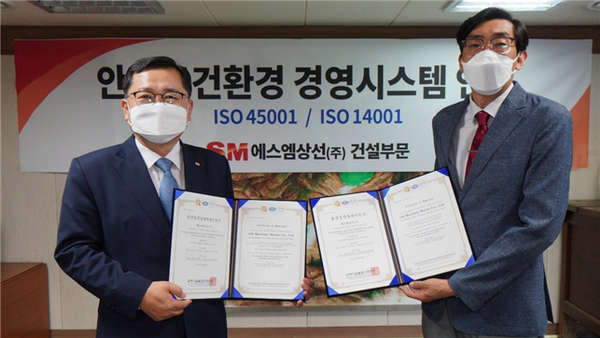 ▲에스엠상선 건설부문 정광열 대표(왼쪽)가 9일 국제표준화기구로부터 안전보건경영시스템과 환경경영시스템인증서를 받고 기념촬영 하고 있다.