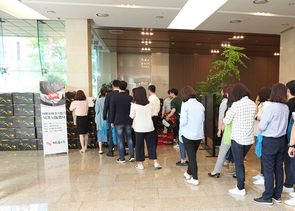▲2018년 NS홈쇼핑 낙과 나눔행사에서 임직원들이 줄을 선 모습