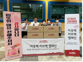▲아웃백 해운대점 관계자들이 도시락 기증 후 기념촬영을 하고 있다.