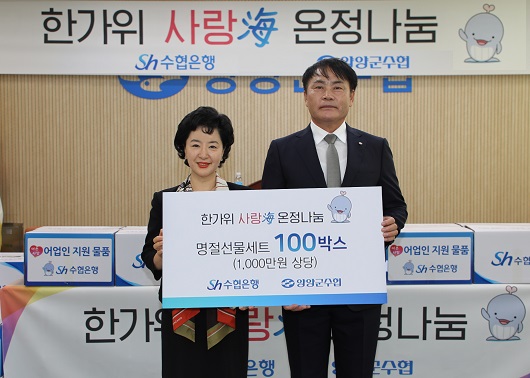 ▲ 지난 25일 양양군수협을 찾은 강신숙 수협은행장(왼쪽)이 김상일 조합장에게 지원물품을 전달하고 기념촬영을 하는 모습.
