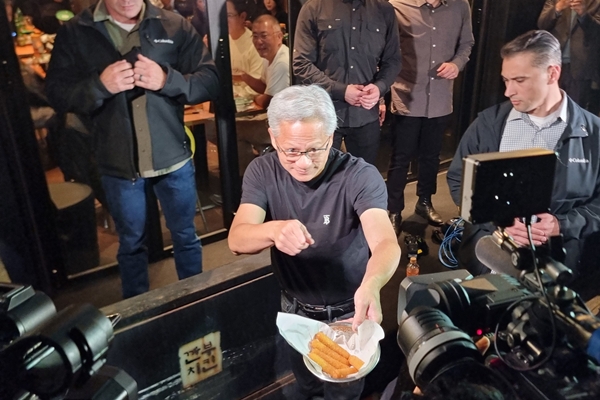 ▲젠슨 황 엔비디아 최고경영자가 취재진에 치즈스틱을 나눠주고 있다.