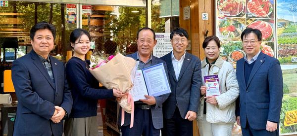 ▲흥국화재 관계자들이 서울 광화문 ‘황금정 식당’을 방문해 응원문구와 꽃다발을 전달하고 있다