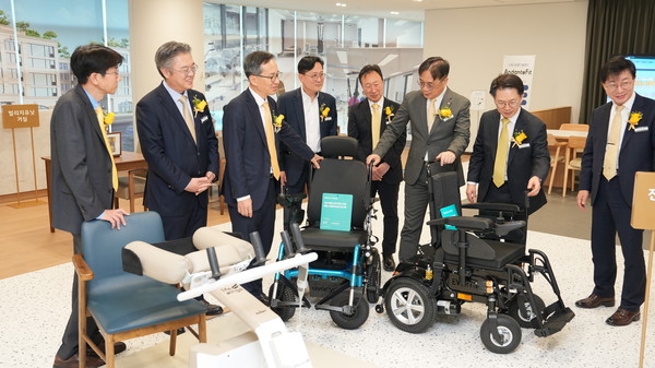 ▲서울 역삼동 KB라이프타워에 마련된 에이지테크랩에서 조영서 KB금융지주 전략담당 부사장(왼쪽에서 두번째), 정문철 KB라이프 대표이사(왼쪽에서 세번째), 박병곤 KB국민은행 이사부행장(왼쪽에서 일곱번째)이 전동휠체어 체험을 하고 있다.